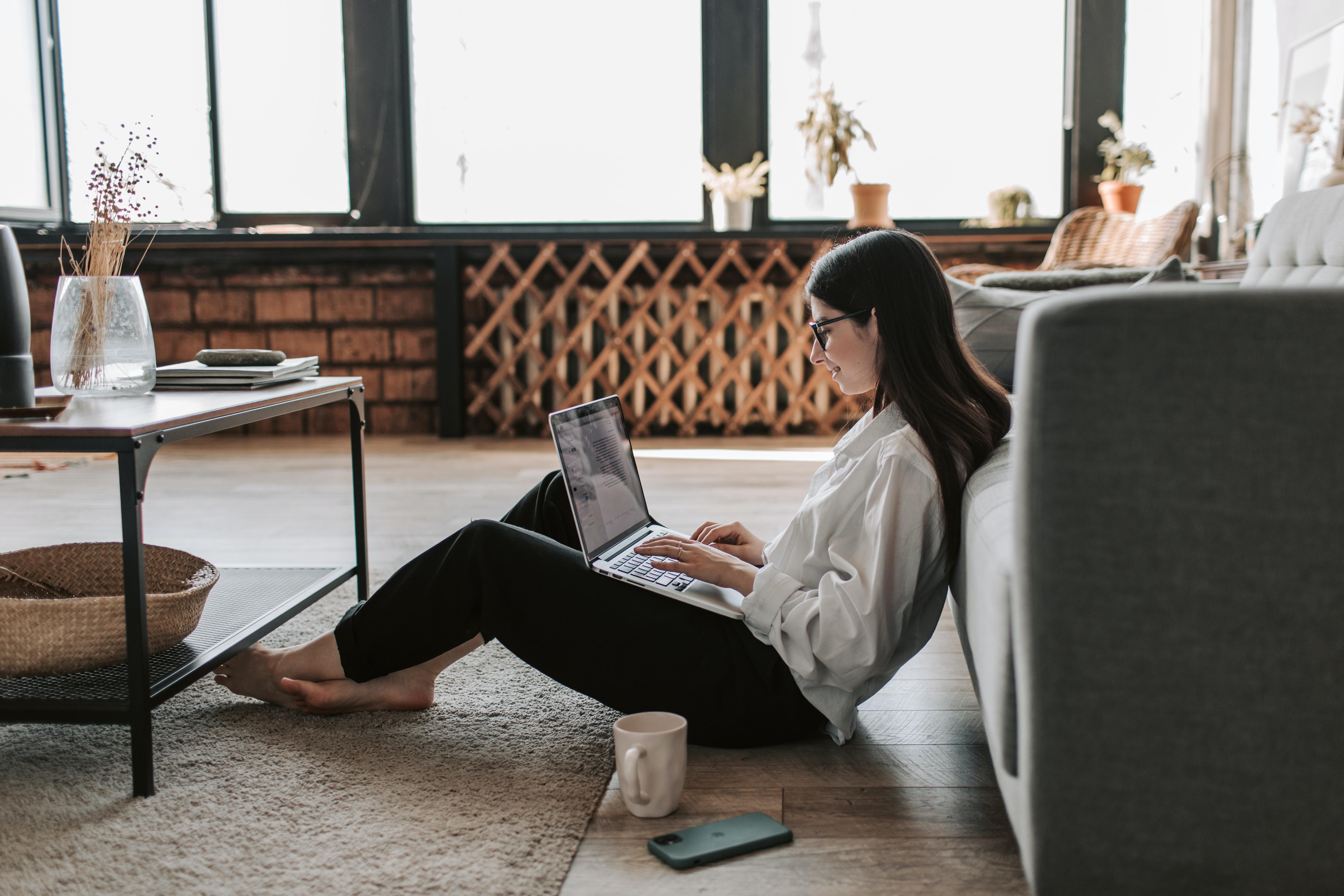 woman working on laptop on the floor at home